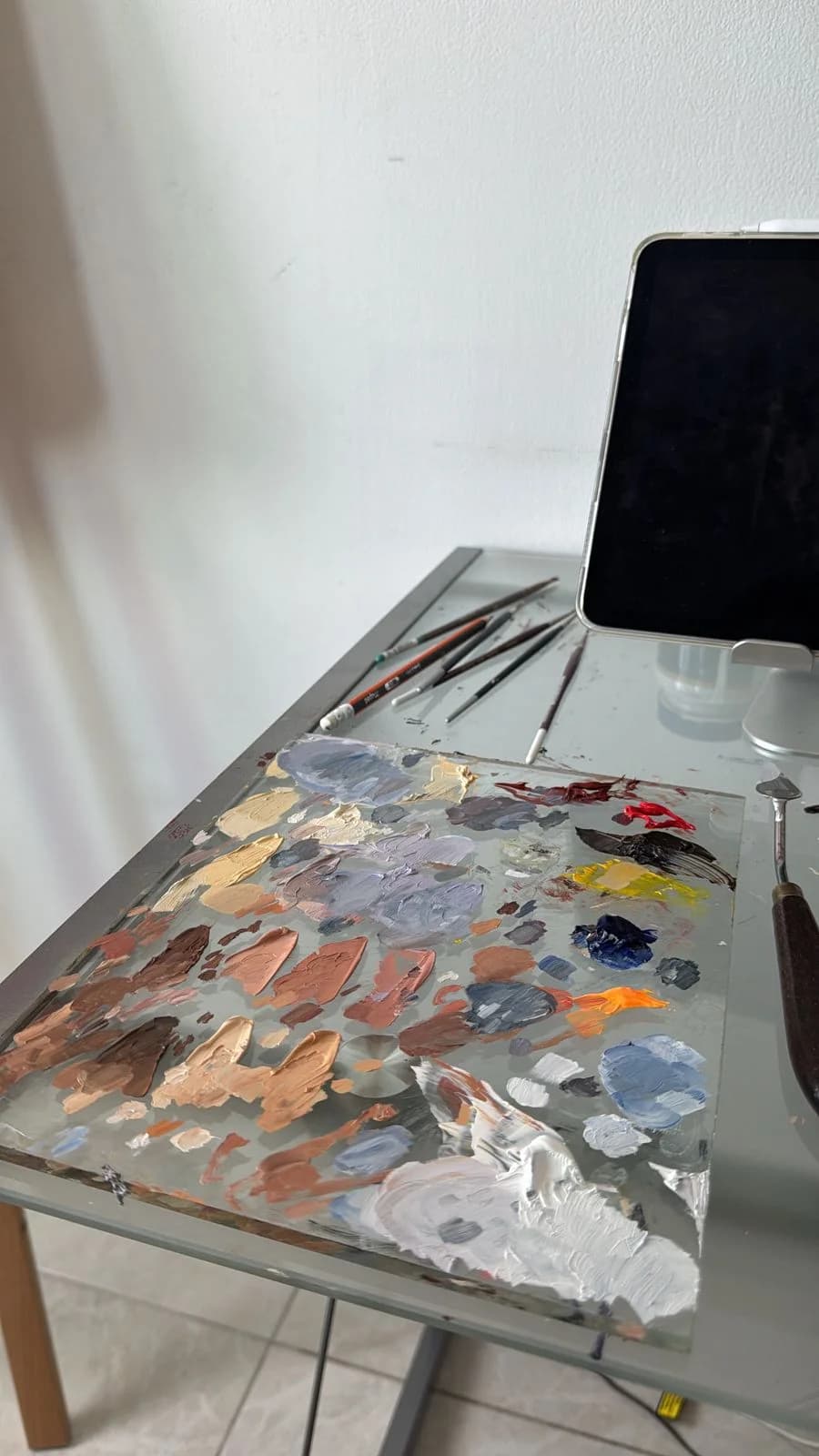 Estudio de arte — pinceles y paleta de colores cálidos sobre lienzo